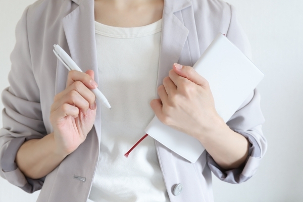 手帳とペンを持ったビジネスウーマン