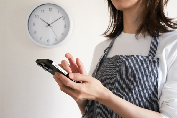 隙間時間にスマホを操作する主婦